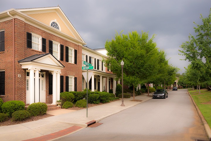 townhouses line street overlooking neighborhood park as stormy skies lie dark beyond