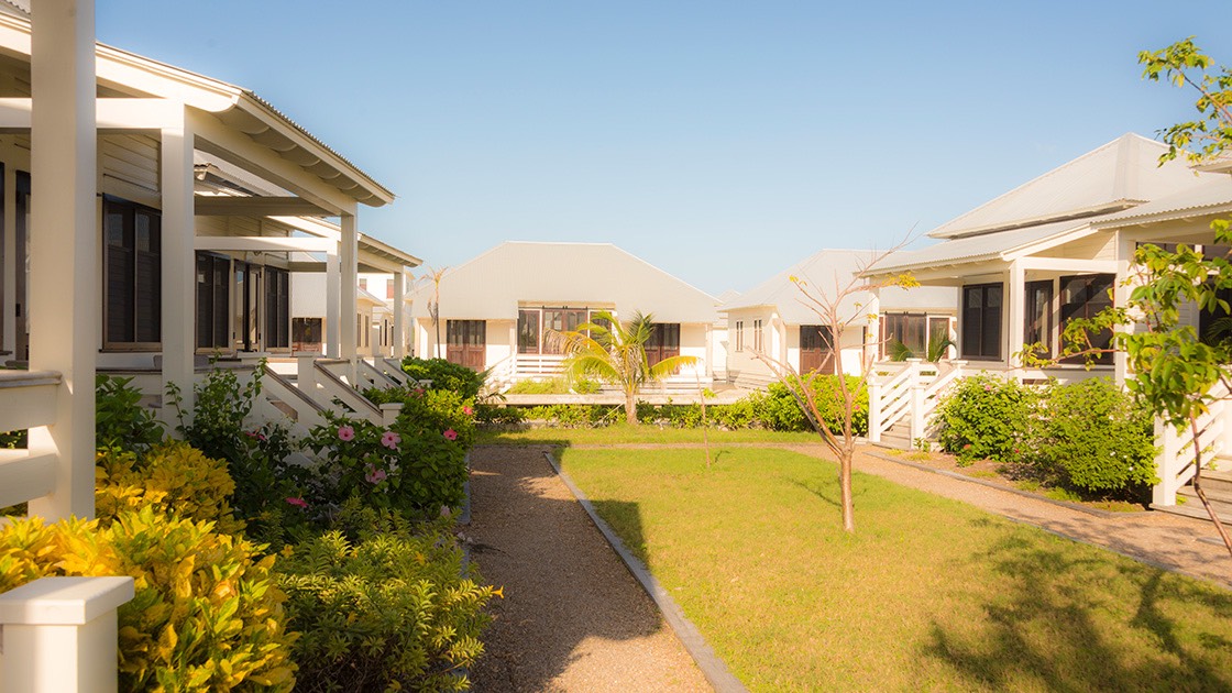 cottage court bathed in warm Caribbean sunlight at Mahogany Bay Village on Ambergris Caye in Belize is backed by a Family Cottage across the canal
